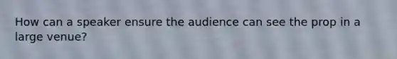 How can a speaker ensure the audience can see the prop in a large venue?