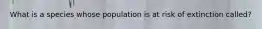 What is a species whose population is at risk of extinction called?