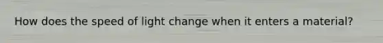 How does the speed of light change when it enters a material?