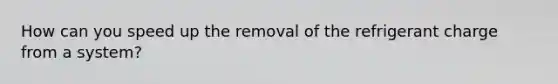 How can you speed up the removal of the refrigerant charge from a system?
