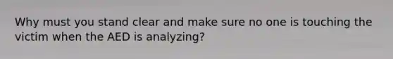 Why must you stand clear and make sure no one is touching the victim when the AED is analyzing?