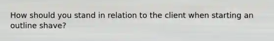 How should you stand in relation to the client when starting an outline shave?