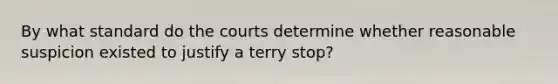 By what standard do the courts determine whether reasonable suspicion existed to justify a terry stop?