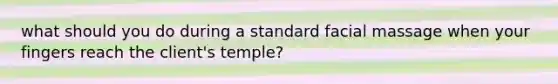 what should you do during a standard facial massage when your fingers reach the client's temple?