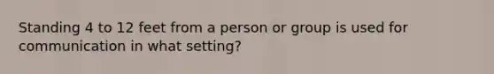 Standing 4 to 12 feet from a person or group is used for communication in what setting?