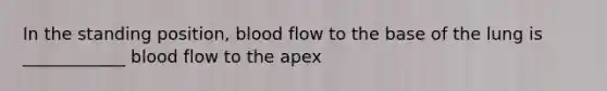 In the standing position, blood flow to the base of the lung is ____________ blood flow to the apex