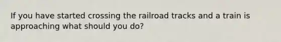 If you have started crossing the railroad tracks and a train is approaching what should you do?