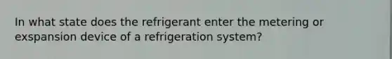 In what state does the refrigerant enter the metering or exspansion device of a refrigeration system?