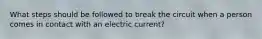 What steps should be followed to break the circuit when a person comes in contact with an electric current?