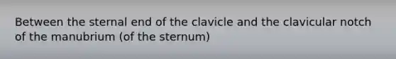 Between the sternal end of the clavicle and the clavicular notch of the manubrium (of the sternum)