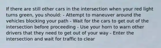 If there are still other cars in the intersection when your red light turns green, you should: - Attempt to maneuver around the vehicles blocking your path - Wait for the cars to get out of the intersection before proceeding - Use your horn to warn other drivers that they need to get out of your way - Enter the intersection and wait for traffic to clear