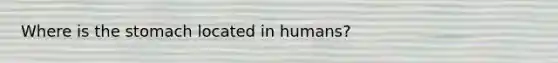 Where is the stomach located in humans?