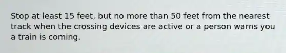 Stop at least 15 feet, but no more than 50 feet from the nearest track when the crossing devices are active or a person warns you a train is coming.