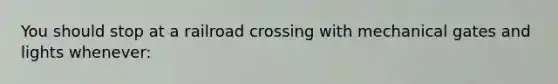 You should stop at a railroad crossing with mechanical gates and lights whenever: