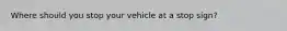 Where should you stop your vehicle at a stop sign?