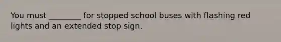 You must ________ for stopped school buses with flashing red lights and an extended stop sign.