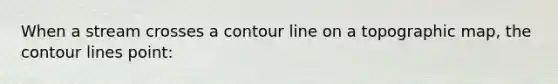 When a stream crosses a contour line on a topographic map, the contour lines point: