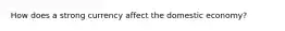 How does a strong currency affect the domestic economy?
