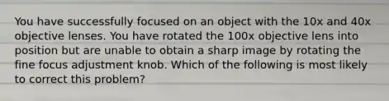 You have successfully focused on an object with the 10x and 40x objective lenses. You have rotated the 100x objective lens into position but are unable to obtain a sharp image by rotating the fine focus adjustment knob. Which of the following is most likely to correct this problem?