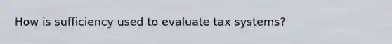 How is sufficiency used to evaluate tax systems?