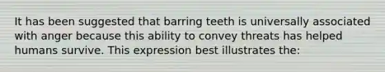 It has been suggested that barring teeth is universally associated with anger because this ability to convey threats has helped humans survive. This expression best illustrates the: