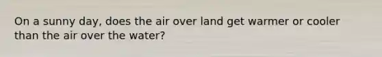 On a sunny day, does the air over land get warmer or cooler than the air over the water?