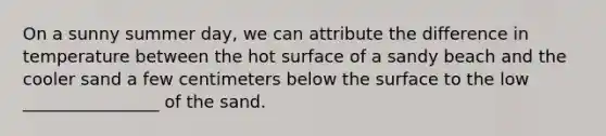 On a sunny summer day, we can attribute the difference in temperature between the hot surface of a sandy beach and the cooler sand a few centimeters below the surface to the low ________________ of the sand.