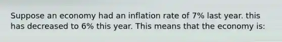 Suppose an economy had an inflation rate of 7% last year. this has decreased to 6% this year. This means that the economy is: