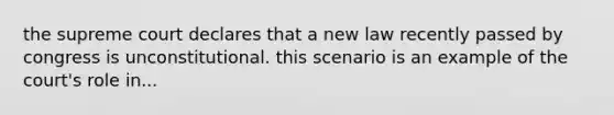the supreme court declares that a new law recently passed by congress is unconstitutional. this scenario is an example of the court's role in...