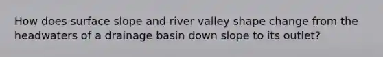 How does surface slope and river valley shape change from the headwaters of a drainage basin down slope to its outlet?