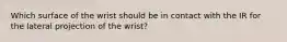 Which surface of the wrist should be in contact with the IR for the lateral projection of the wrist?