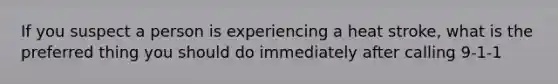 If you suspect a person is experiencing a heat stroke, what is the preferred thing you should do immediately after calling 9-1-1