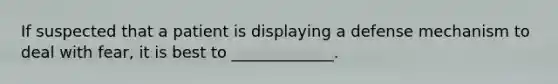 If suspected that a patient is displaying a defense mechanism to deal with fear, it is best to _____________.