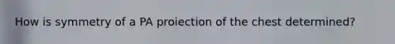 How is symmetry of a PA proiection of the chest determined?