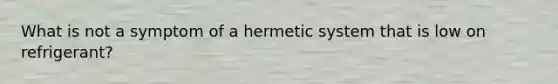 What is not a symptom of a hermetic system that is low on refrigerant?