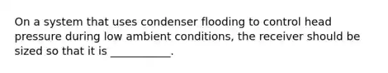 On a system that uses condenser flooding to control head pressure during low ambient conditions, the receiver should be sized so that it is ___________.