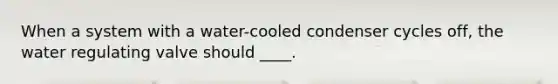 When a system with a water-cooled condenser cycles off, the water regulating valve should ____.