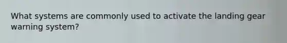 What systems are commonly used to activate the landing gear warning system?