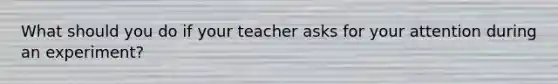 What should you do if your teacher asks for your attention during an experiment?