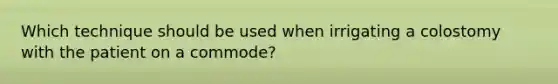 Which technique should be used when irrigating a colostomy with the patient on a commode?