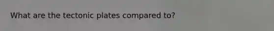 What are the tectonic plates compared to?