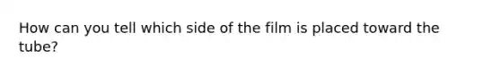 How can you tell which side of the film is placed toward the tube?