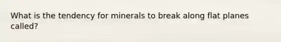 What is the tendency for minerals to break along flat planes called?