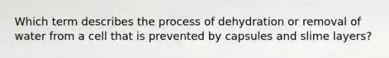 Which term describes the process of dehydration or removal of water from a cell that is prevented by capsules and slime layers?