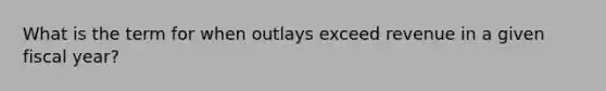 What is the term for when outlays exceed revenue in a given fiscal year?