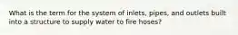 What is the term for the system of inlets, pipes, and outlets built into a structure to supply water to fire hoses?