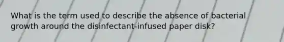 What is the term used to describe the absence of bacterial growth around the disinfectant-infused paper disk?