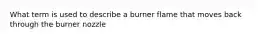 What term is used to describe a burner flame that moves back through the burner nozzle