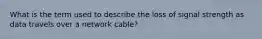 What is the term used to describe the loss of signal strength as data travels over a network cable?