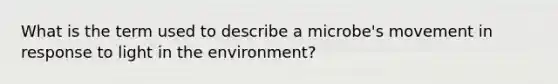 What is the term used to describe a microbe's movement in response to light in the environment?